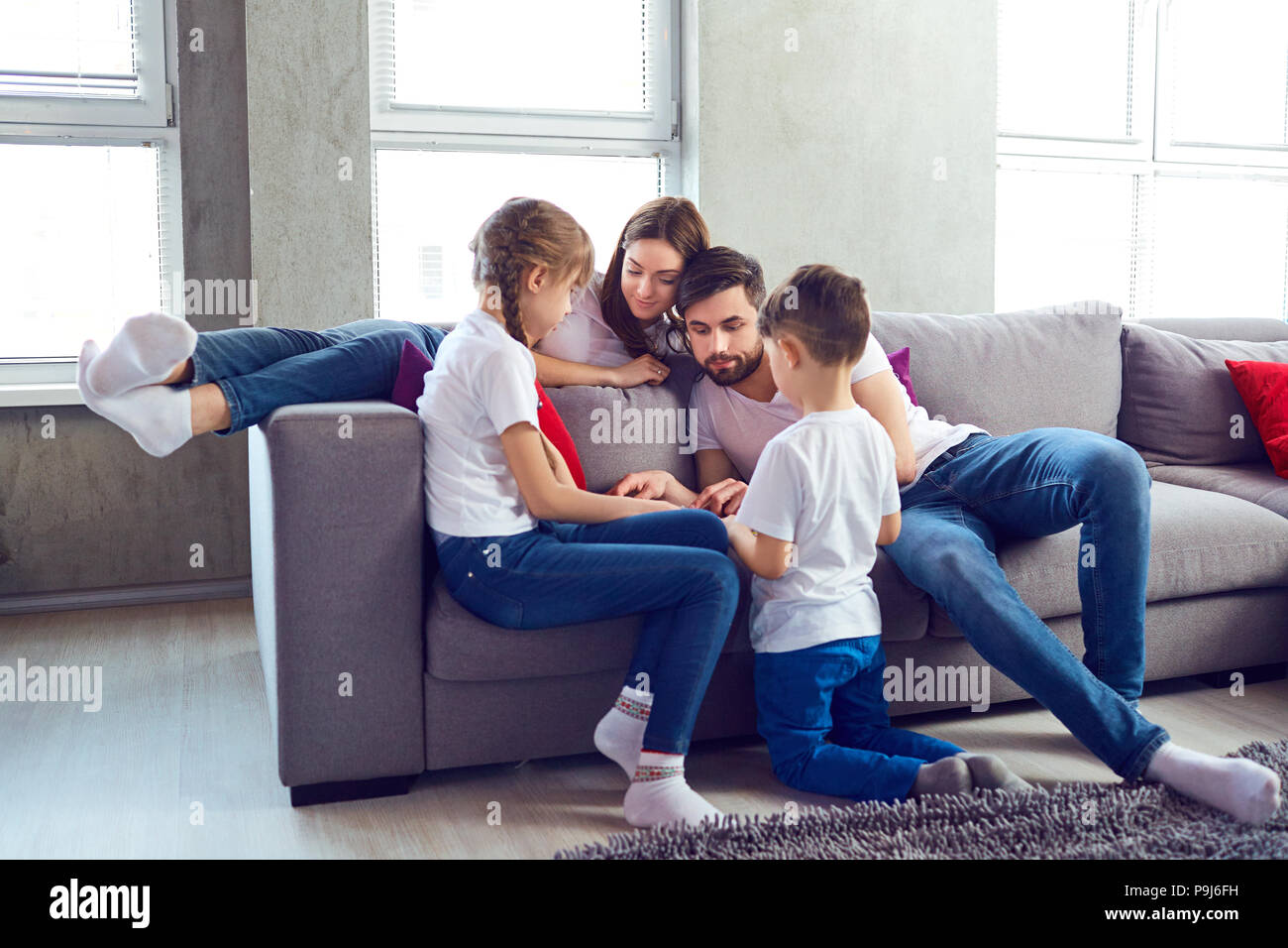 Mother, father and children play together. Stock Photo