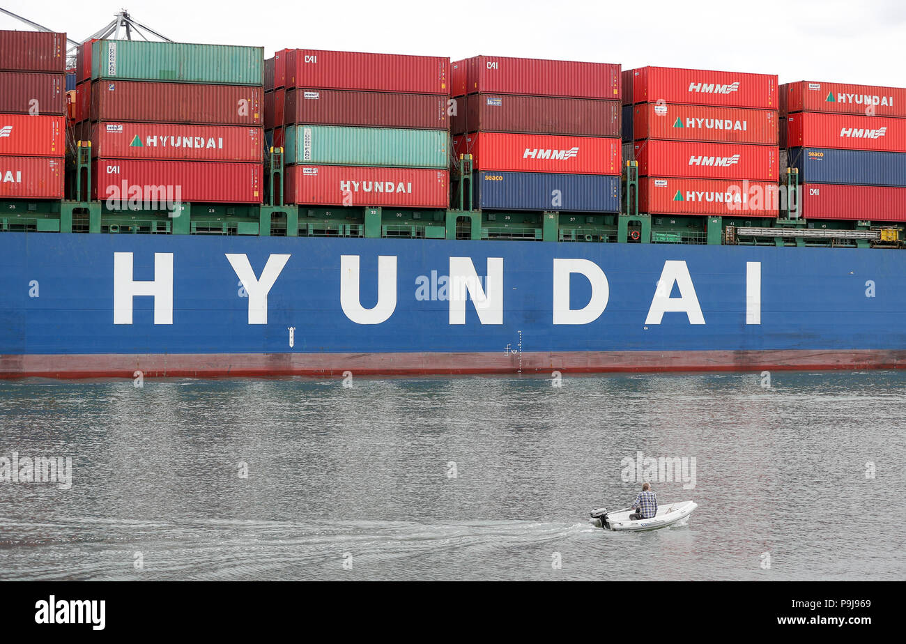 A small RIB makes it's way past the container ship Hyundai Dynasty as ...