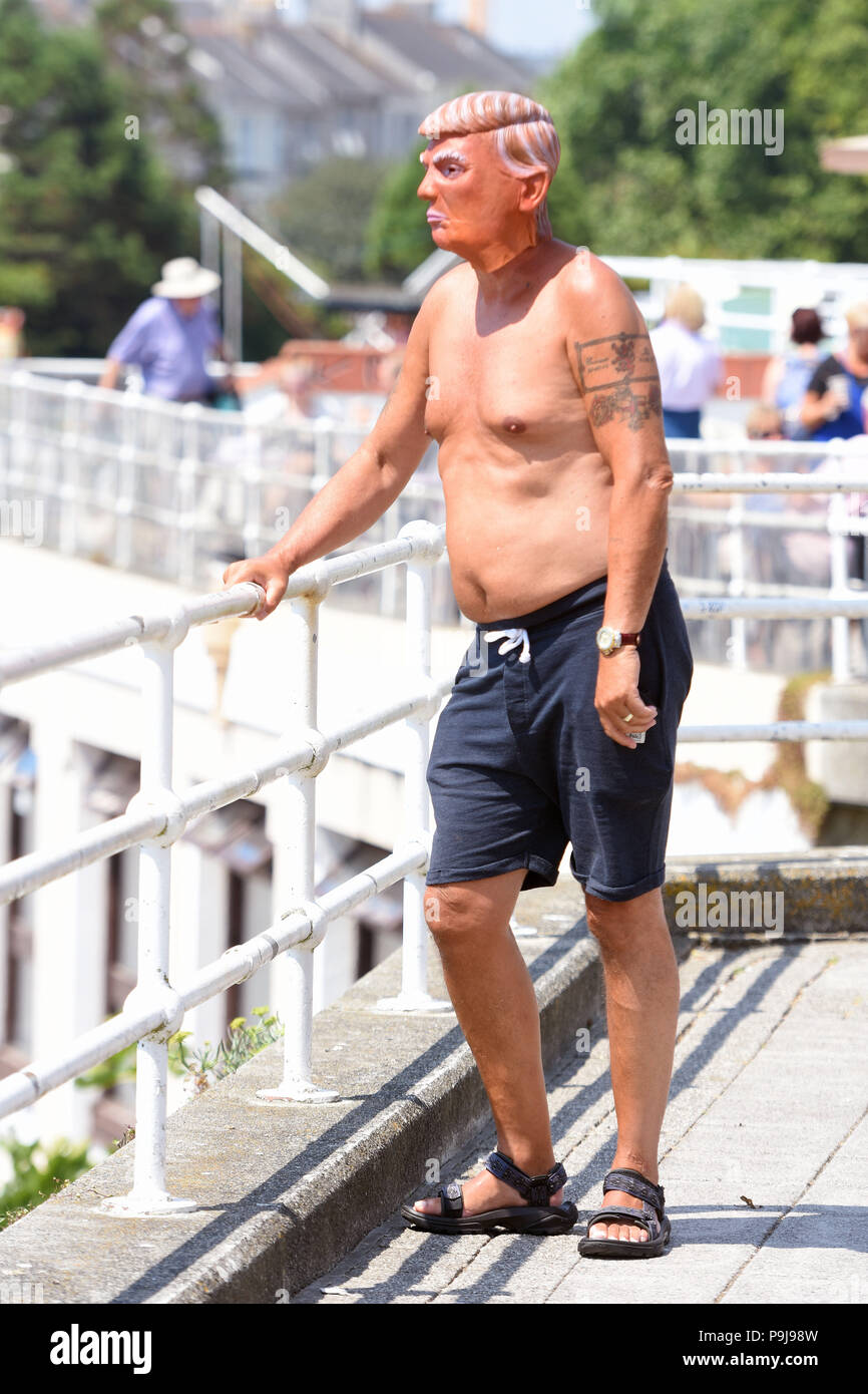 Man in Donald Trump mask enjoying the sun in Plymouth,Devon,UK Stock Photo