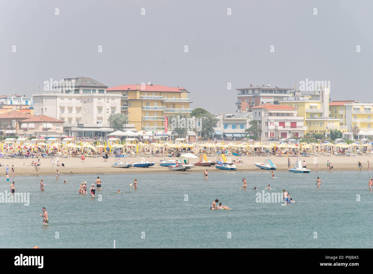 Europe, Italy, Veneto, Caorle. People at the beach, sunbathing and swimming. Relax at the Adriatic Sea coast. Stock Photo