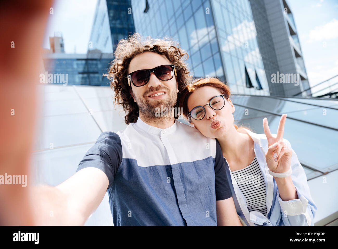Young woman wearing glasses making funny face for selfie Stock Photo