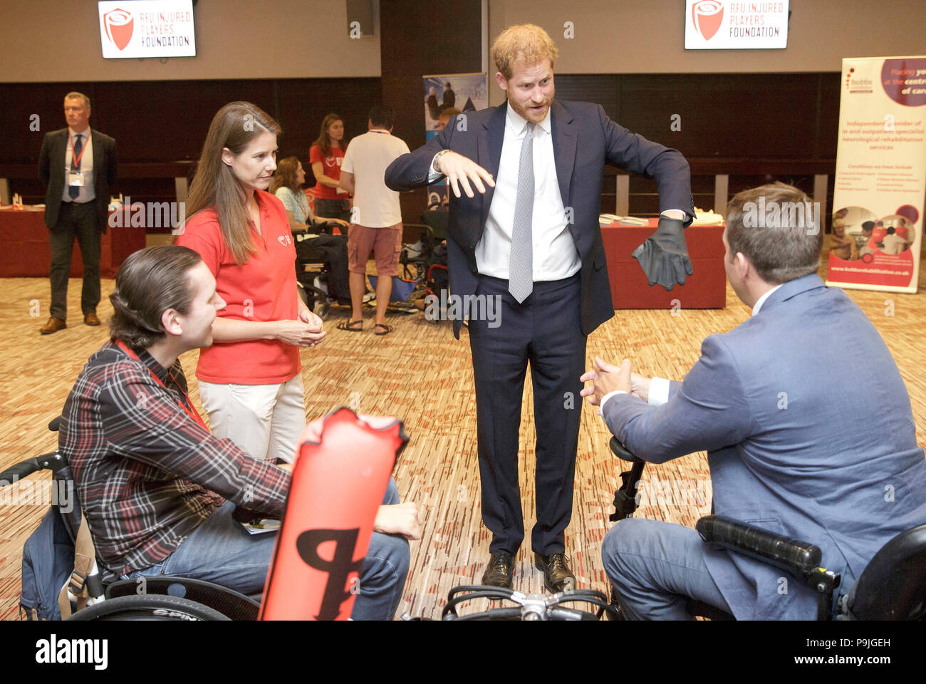 The Duke of Sussex with Karen Hood, head of the Injured Players Foundation (IPF), tries a diving glove as he meets scuba divers Tom Horay (left) and Tom Hugues who plan to teach diving to (IPF) members, during a visit to the RFU Injured Players Foundation's annual Client Forum at Twickenham Stadium, in London. Stock Photo