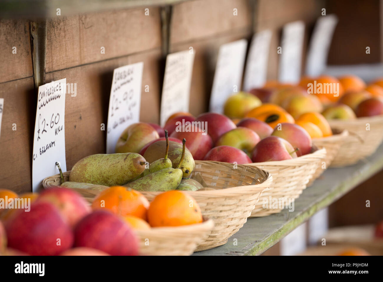 Bowls of fruit for sale including oranges, pears and apples on display outside a greengrocers shop in North Dorset England UK GB. Stock Photo