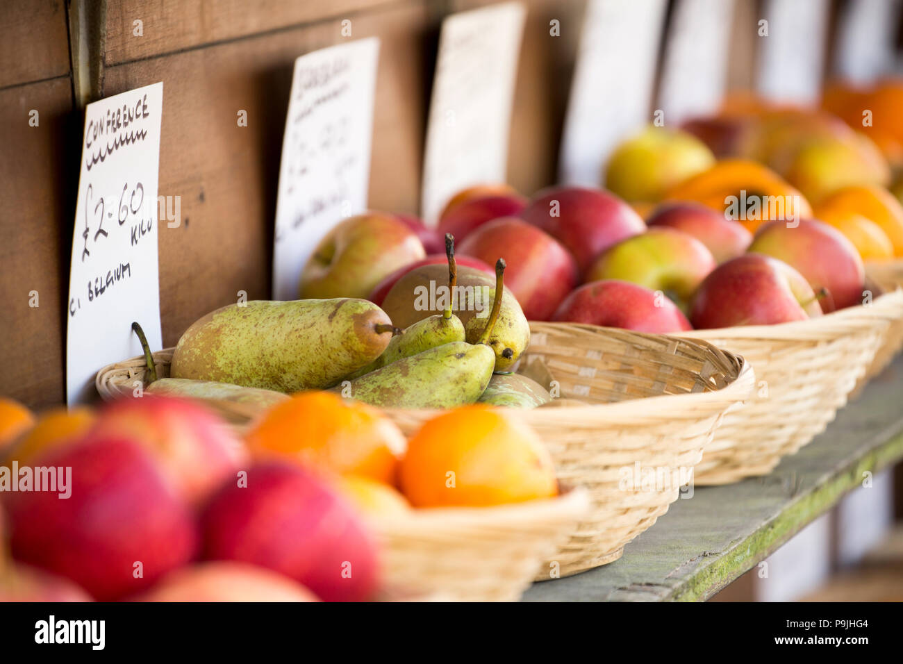Bowls of fruit for sale including oranges, pears and apples on display