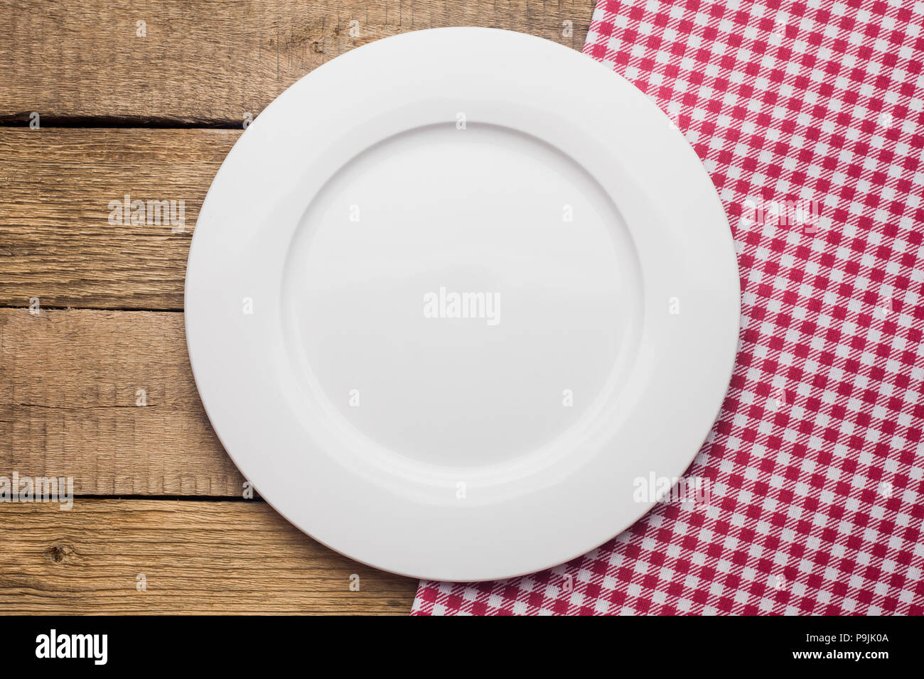 empty plate on a wooden background, a napkin in a red and white  Stock Photo