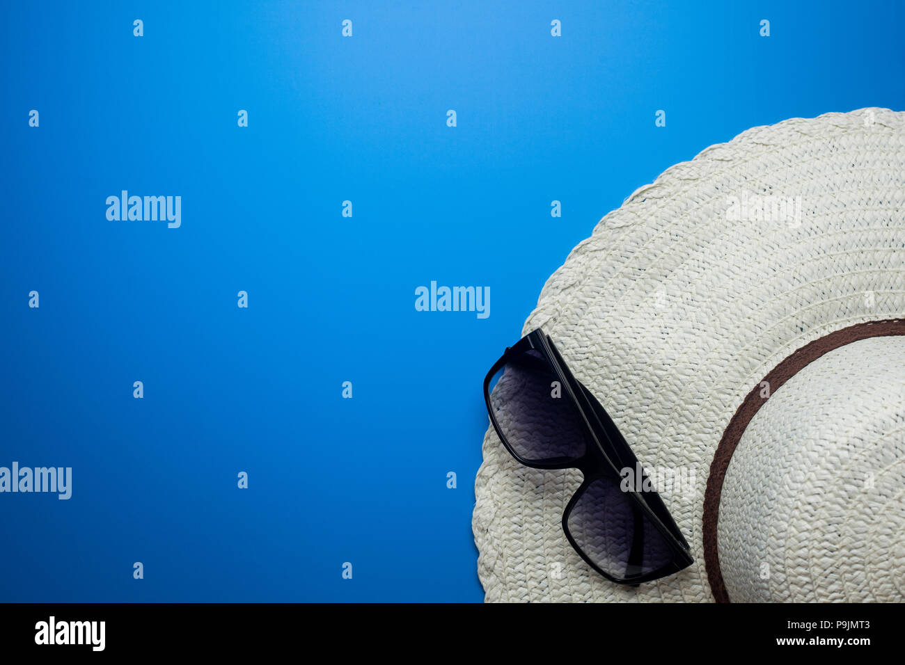 Summer concept, hat and glasses on a blue background, vacation at sea Stock Photo