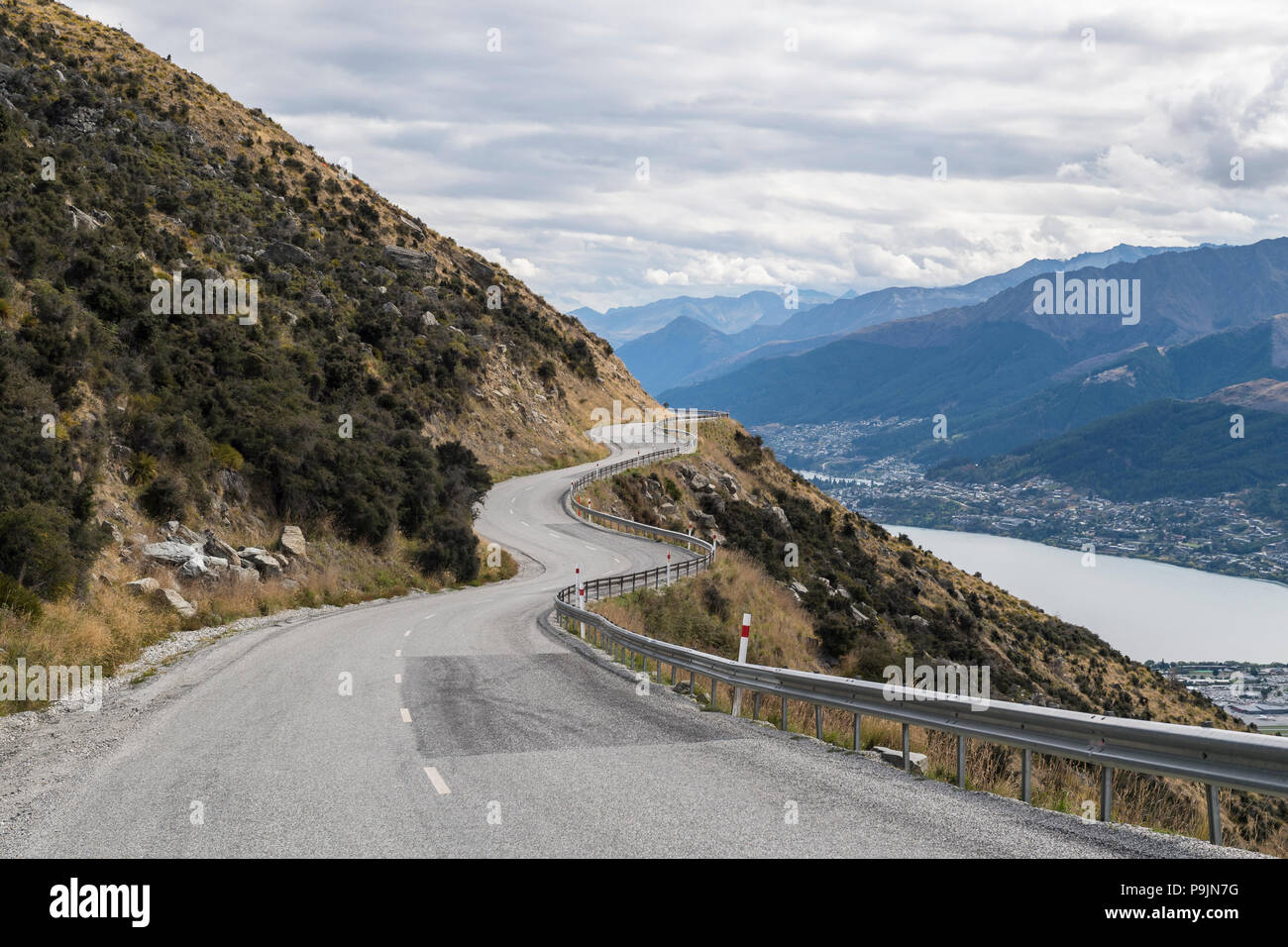 Curvy road into the mountain range The Remarkables, below Queenstown and Lake Wakatipu, Otago, South Island, New Zealand Stock Photo