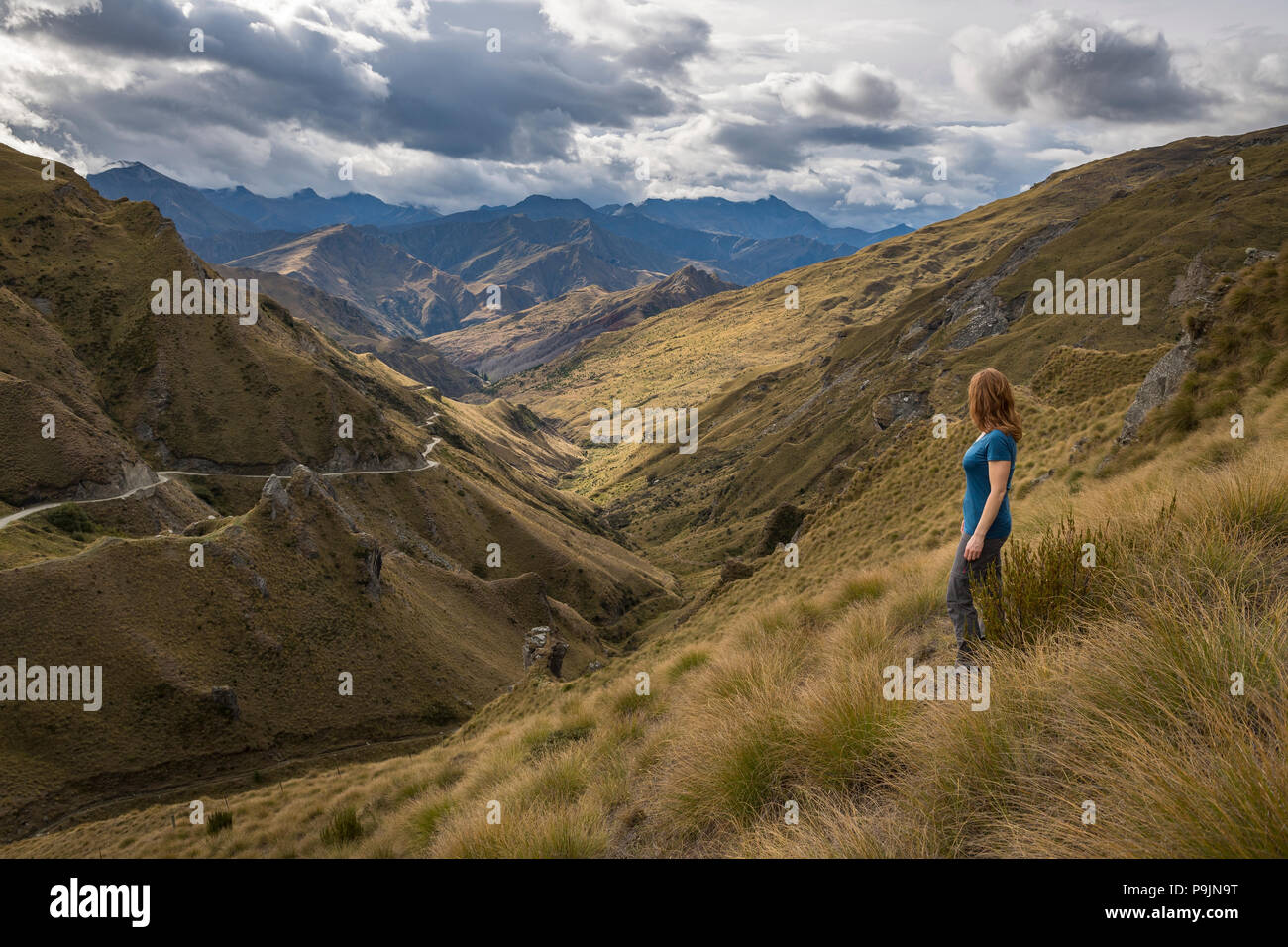 Female hiker looking down towards Skippers Canyon, Queenstown, Otago, South Island, New Zealand Stock Photo