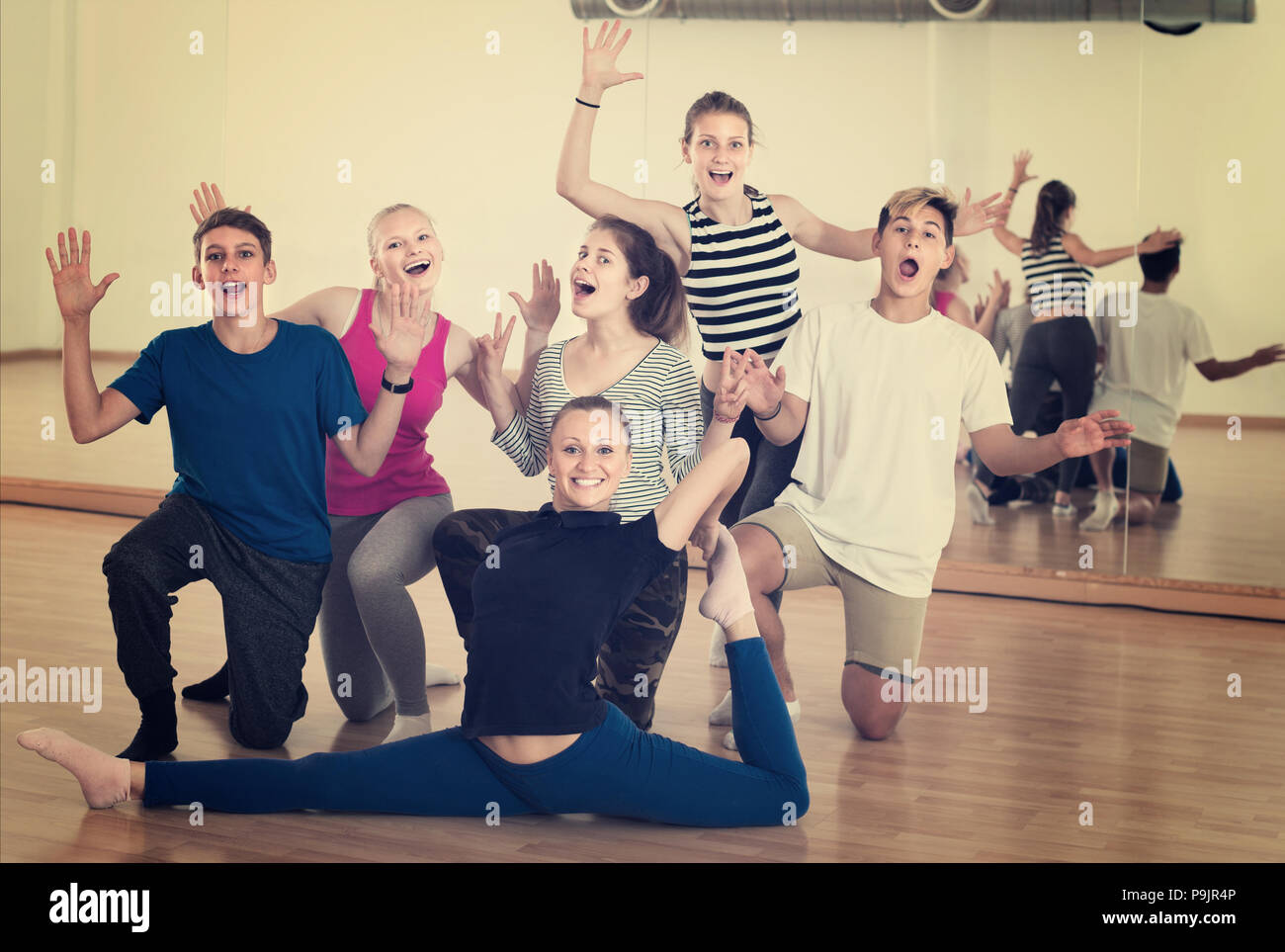 Group of happy teen with teacher in dance studio smiling and posing ...