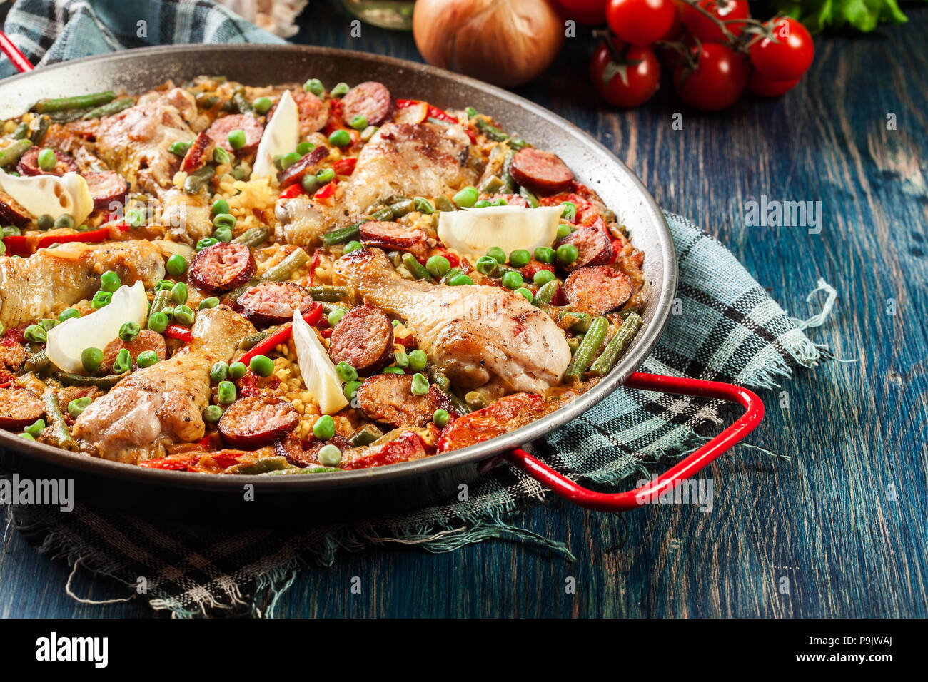 Traditional paella with chicken legs, sausage chorizo and vegetables