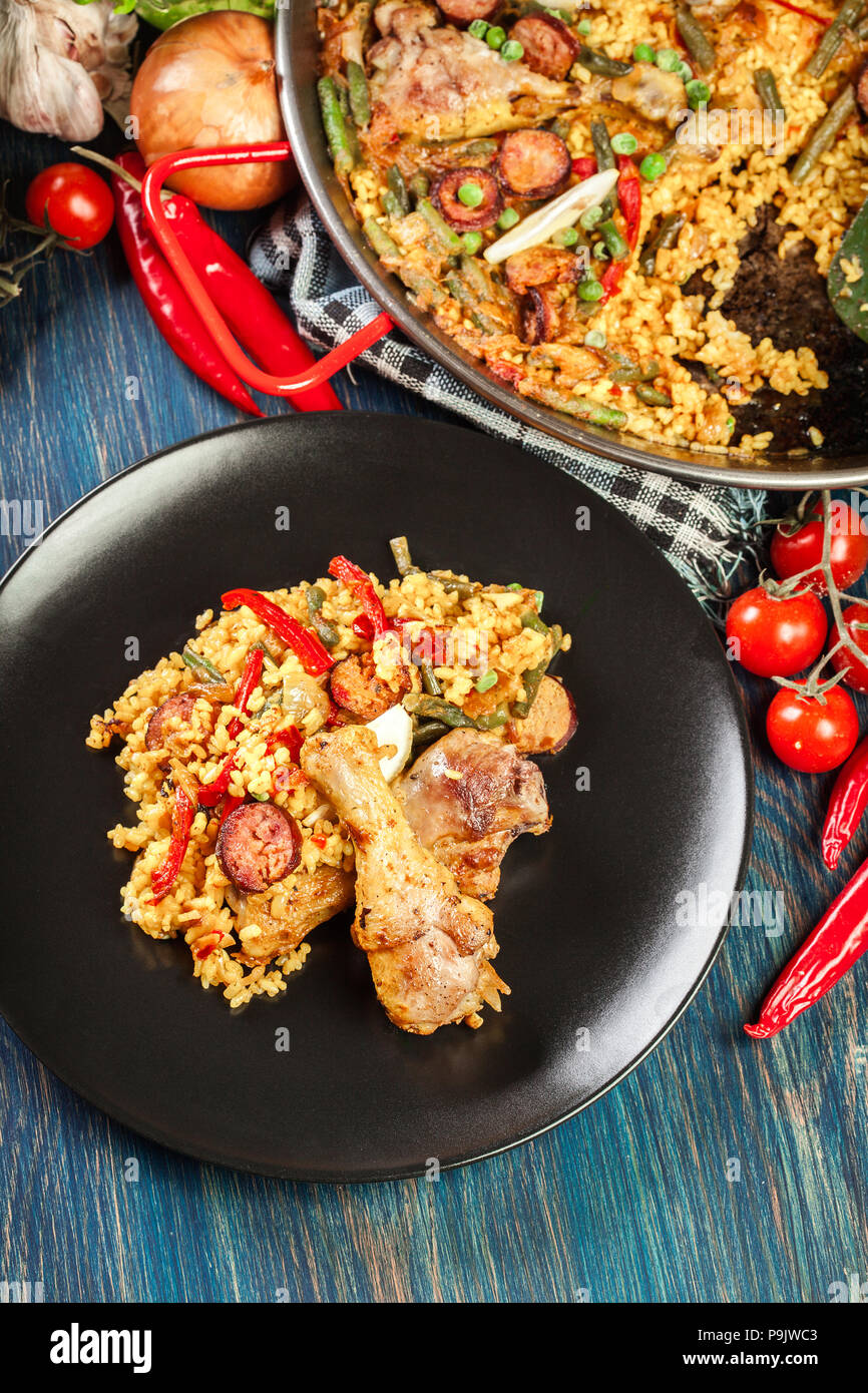 Traditional paella with chicken legs, sausage chorizo and vegetables