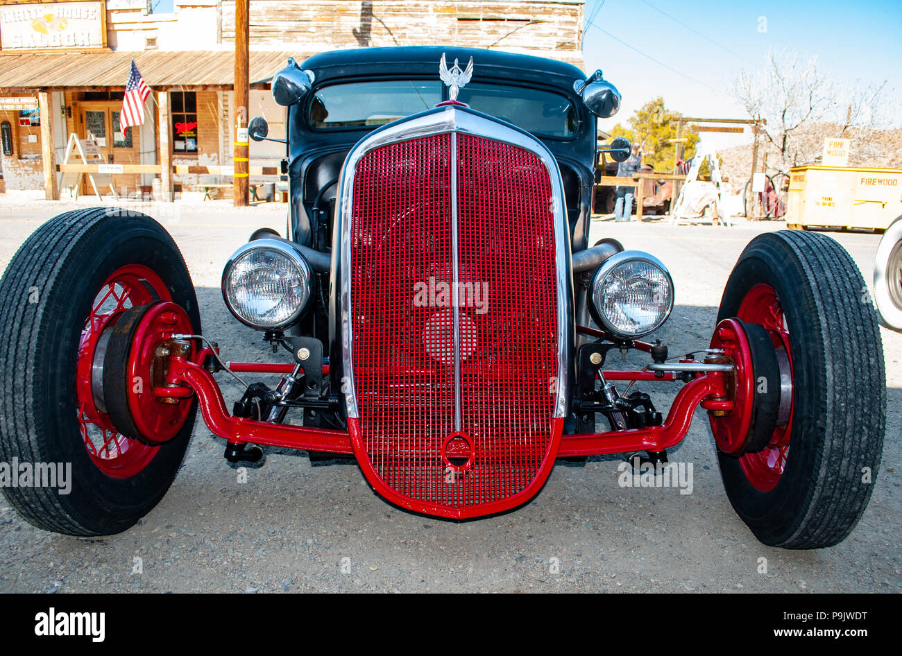hot rod in red and black in an old ghost town with big white wall tires and a custom red wire grill Stock Photo