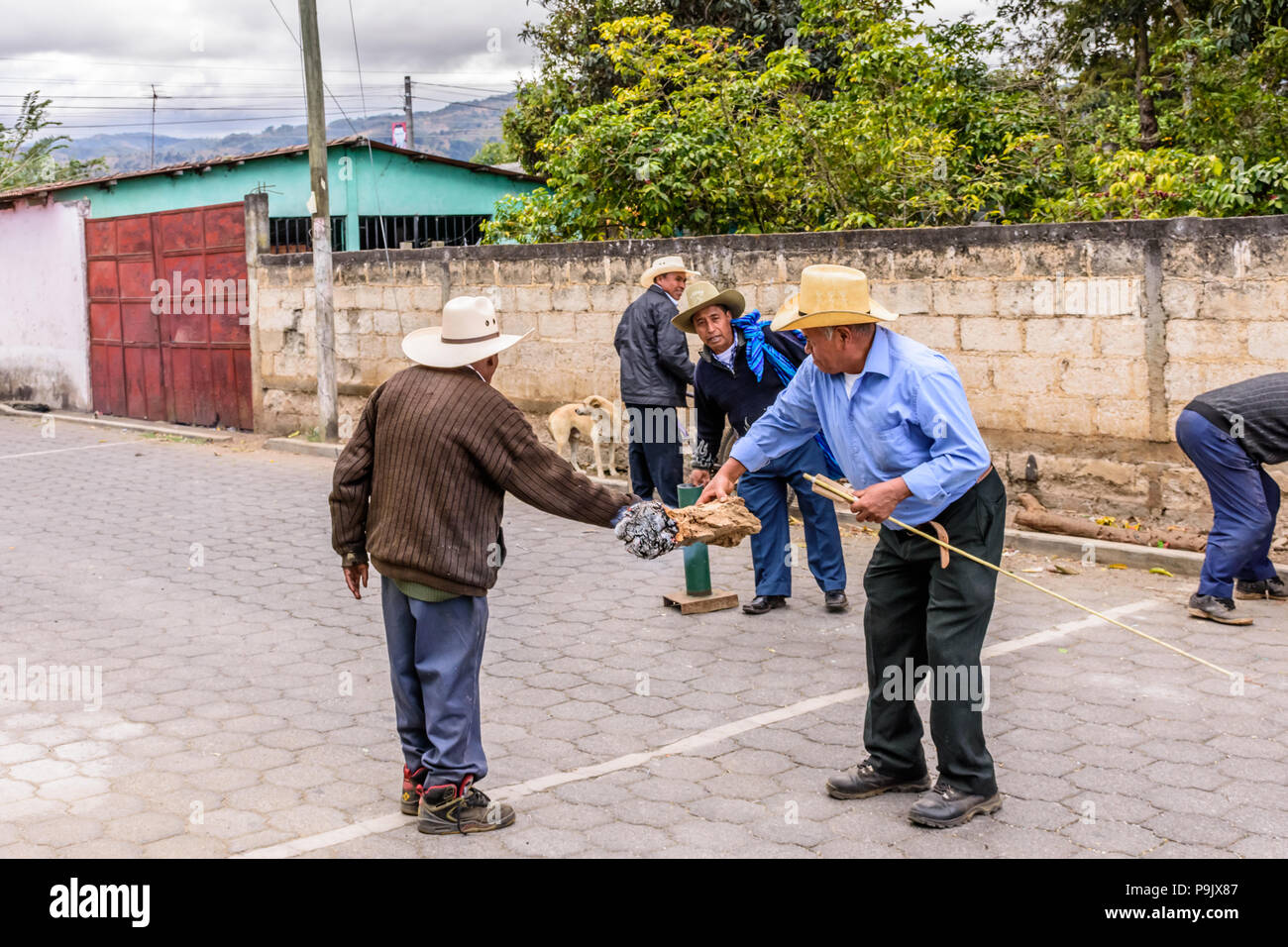 Parramos, Guatemala - December 28, 2016: Local men ignite rocket in street behind procession in village near UNESCO World Heritage Site of Antigua. Stock Photo