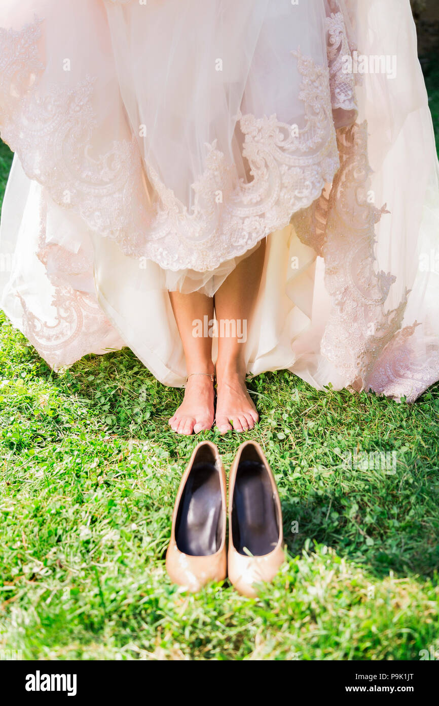 Barefoot bride on grass with shoes Stock Photo - Alamy