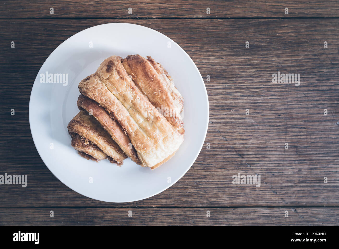 top view of Franzbroetchen pastry on plate on rustic wooden table Stock Photo