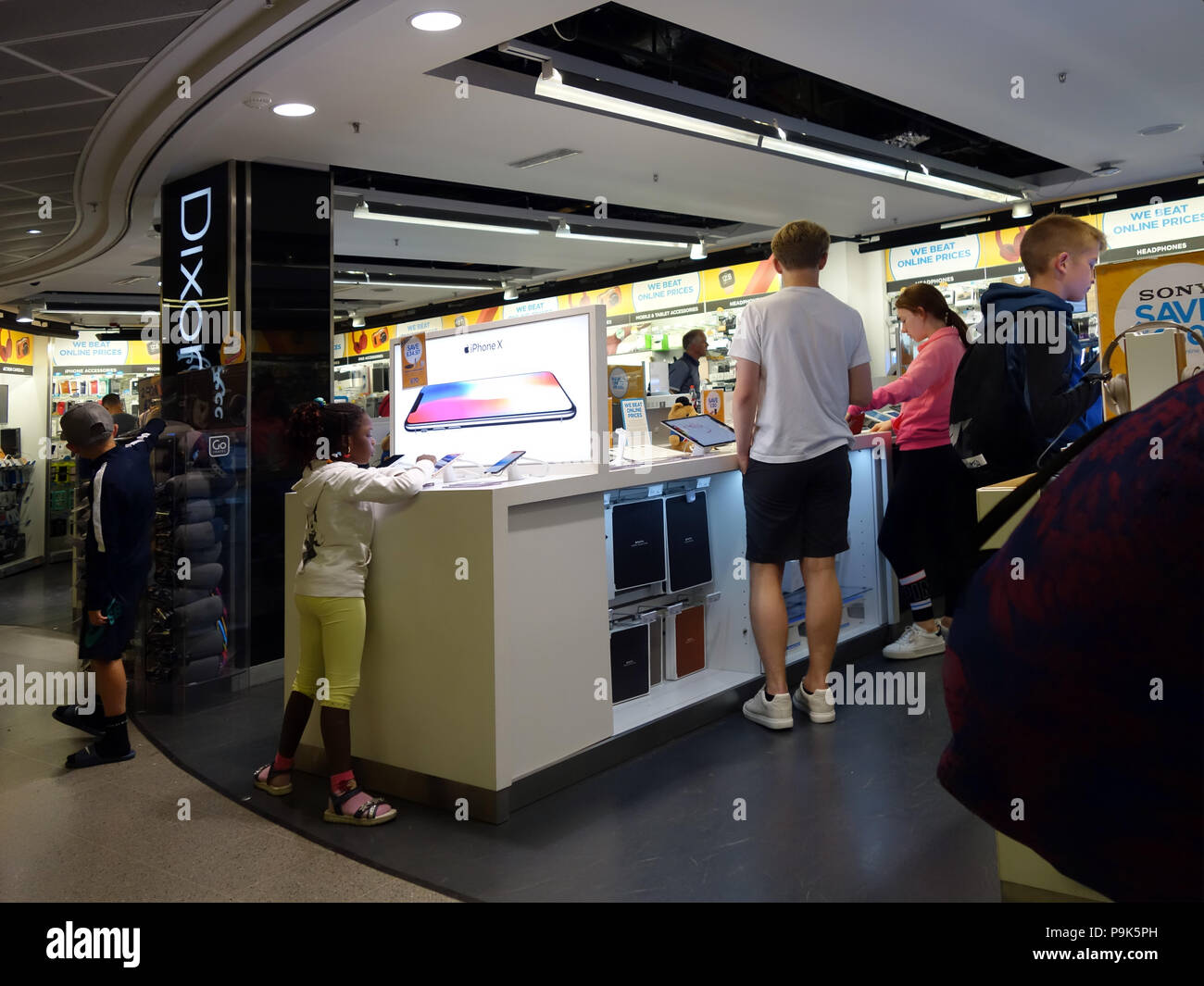 Young people looking at the electronic items on sale in the Duty Free Lounge Electronic section at Manchester Airport. Stock Photo