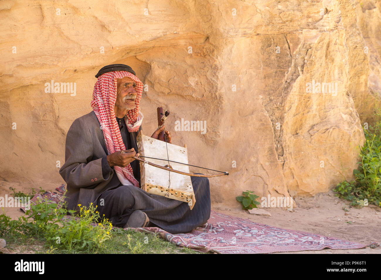 Old bedouin man with his self made oud singing in the dessert Stock Photo