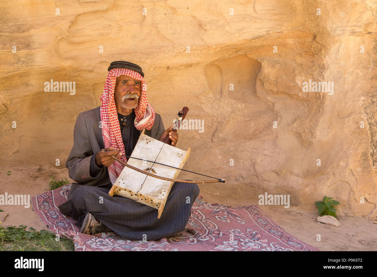 Old bedouin man with his self made oud singing in the dessert Stock Photo