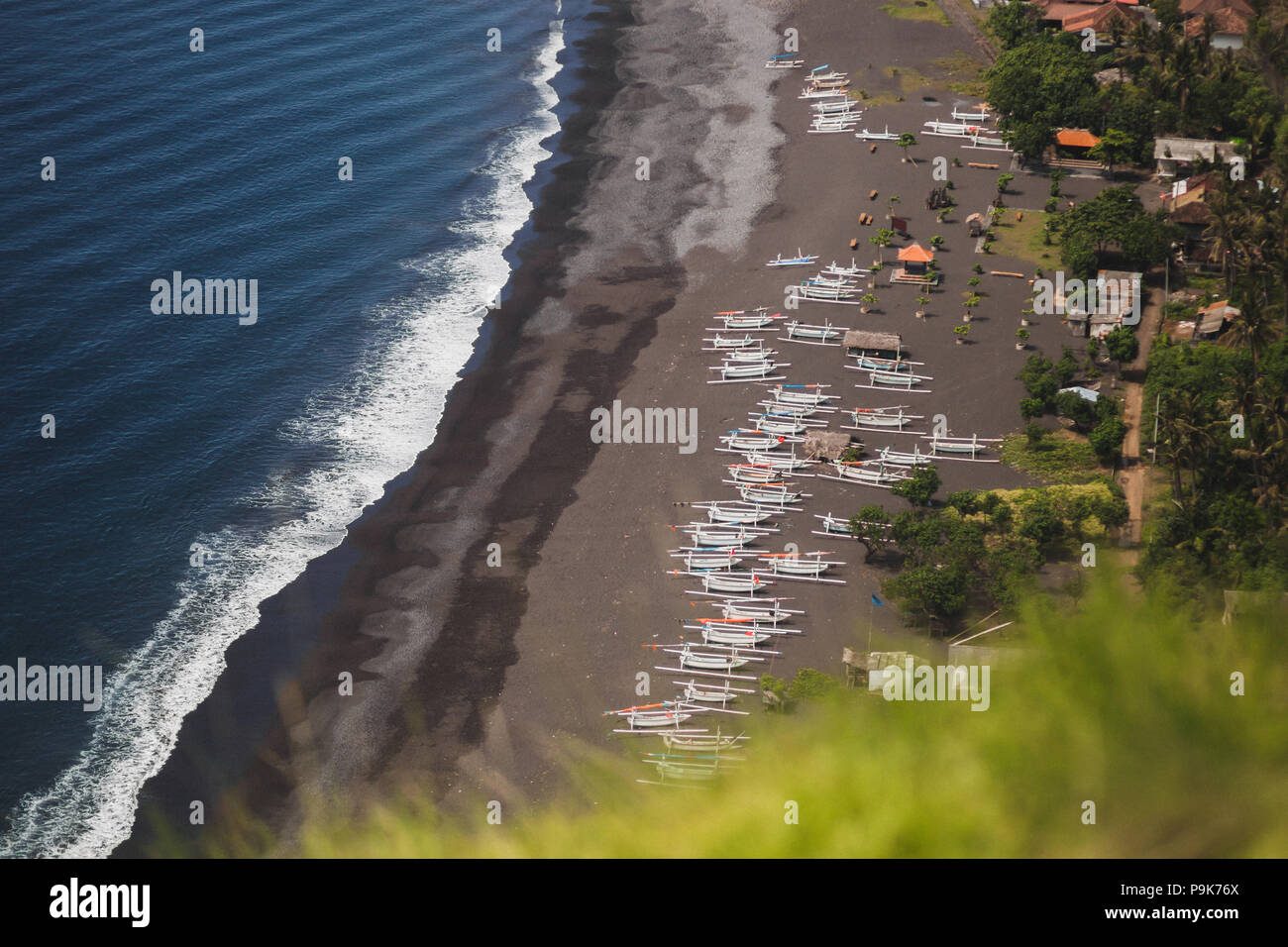 Black sand beach with a lot of traditional balinese boats, view from cliff in Candidasa Stock Photo