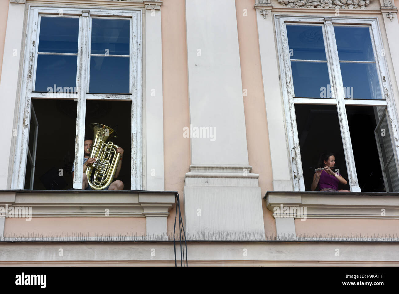 Musicians playing performing from apartment windows in Krakow Poland Stock Photo