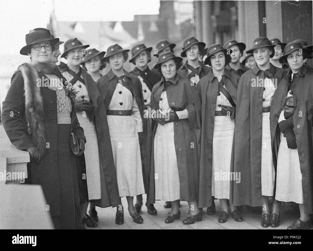266 SLNSW 43889 Group of graduate nurses in hats and rain cloaks Stock Photo