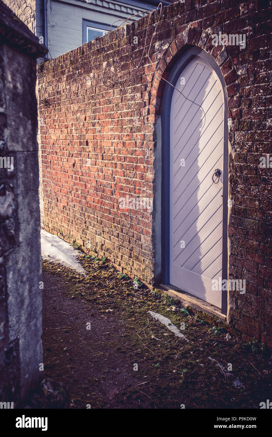 Narrow alleyway in a churchyard in Southern England, UK Stock Photo