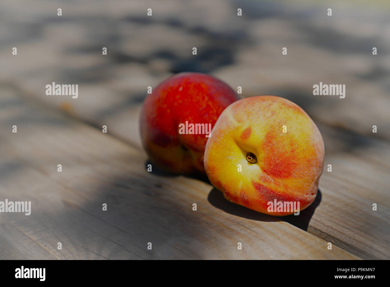 Two ripe peaches on wooden table Stock Photo