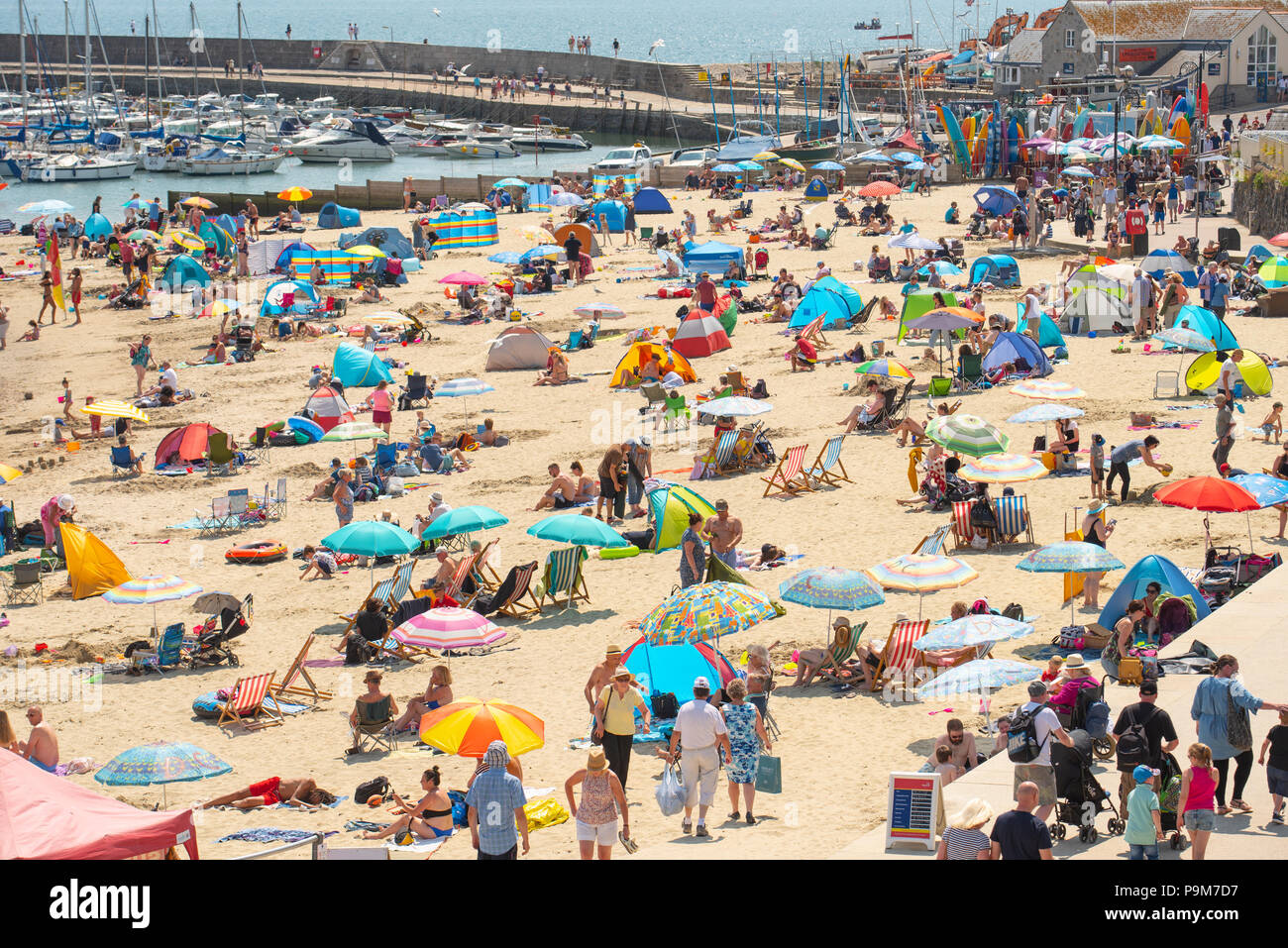 Lyme Regis, Dorset, UK. 19th July 2018.  UK Weather: Very warm and sunny in Lyme Regis.  Sunseekers flock to the beach to enjoy another day of hot sunshine and clear blue sky in the seaside resort of Lyme Regis. Credit: Celia McMahon/Alamy Live News Stock Photo