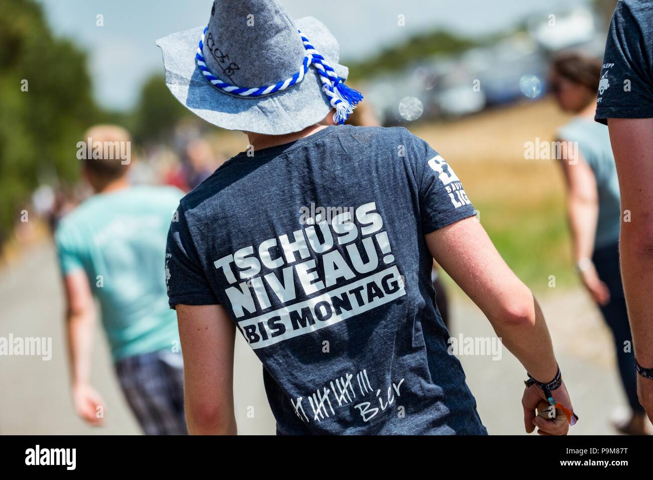 Cuxhaven, Germany. 19th July, 2018. A visitor at the Deichbrand festival wearing a t-shirt with the words 'Tschüss Niveau! Bis Montag' (lit. bye Niveau! See you Monday). 50,000 visitors are expected to attend in the next four days and around 100 bands and shows are also expected. Credit: Mohssen Assanimoghaddam/dpa/Alamy Live News Stock Photo