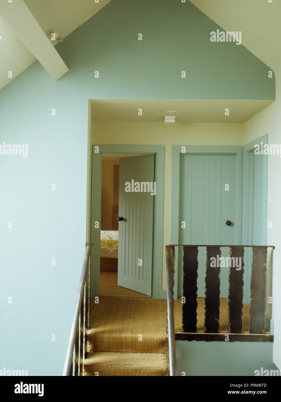Sisal carpet on pastel turquoise landing in barn conversion Stock Photo