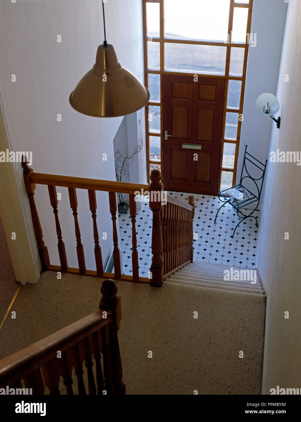 Birds-eye view from landing of a nineties ahall with a black+white tiled floor Stock Photo