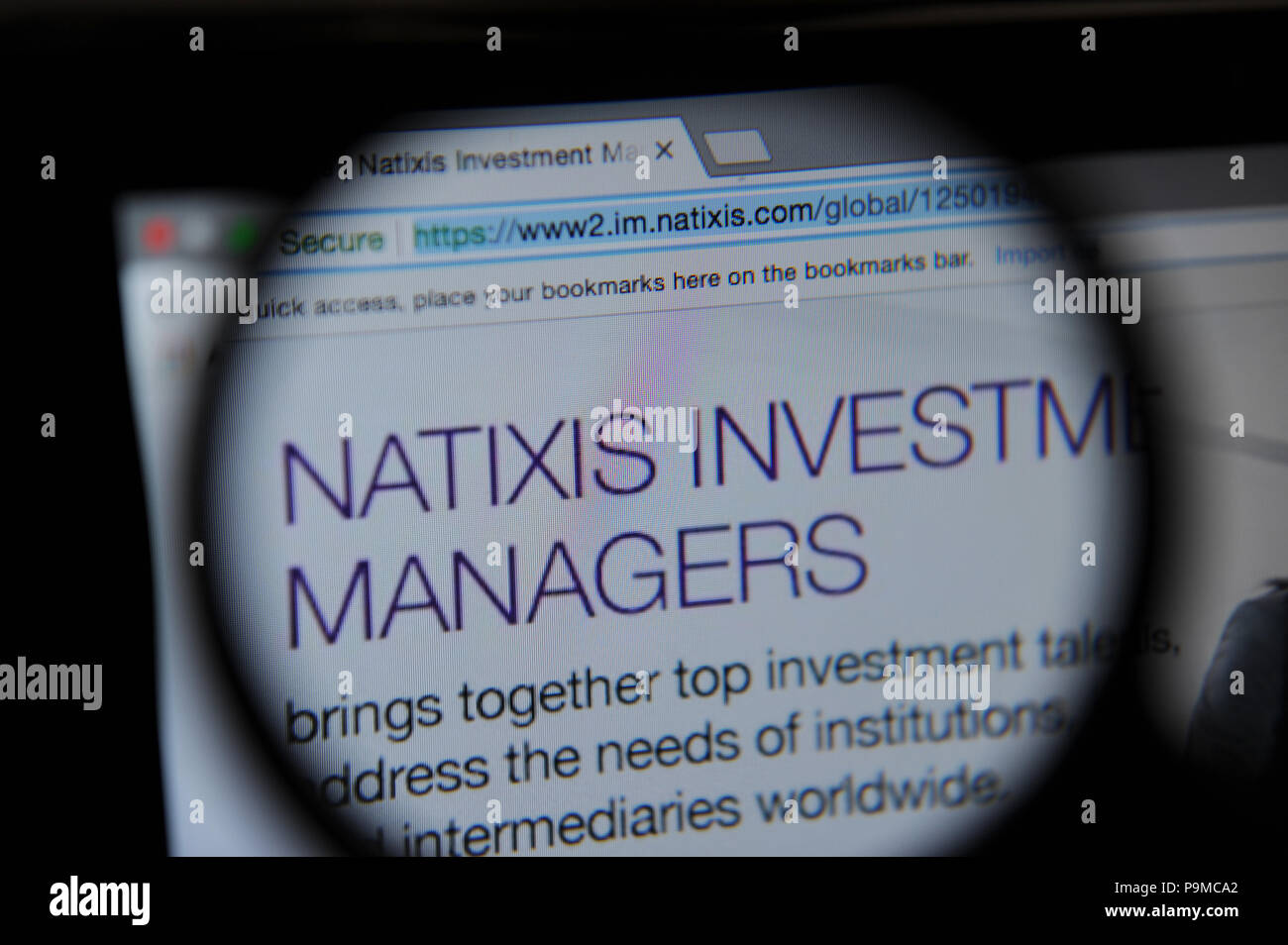 The Natixis Investment Managers website seen through a magnifying glass Stock Photo