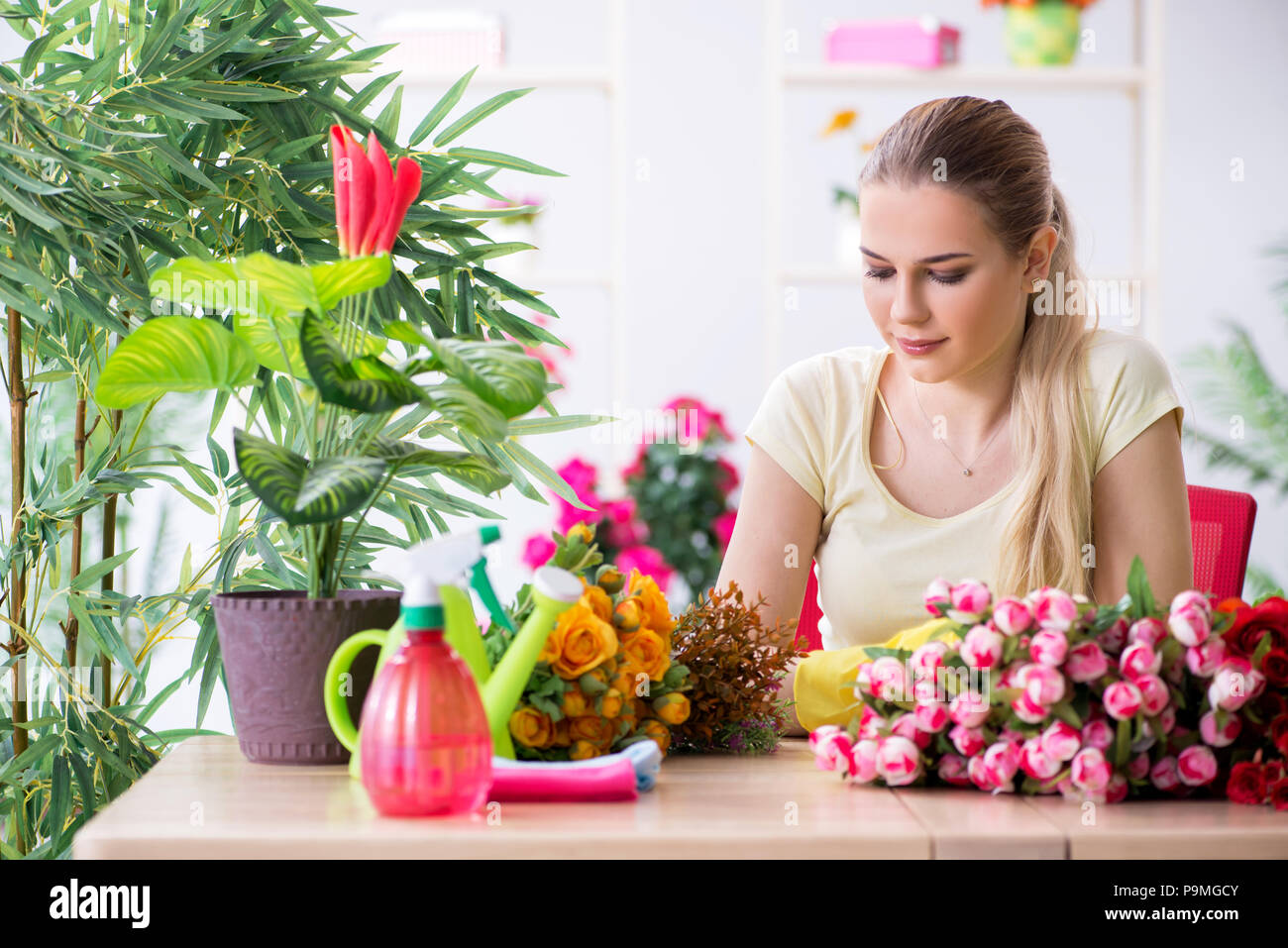 Young woman watering plants in her garden Stock Photo - Alamy