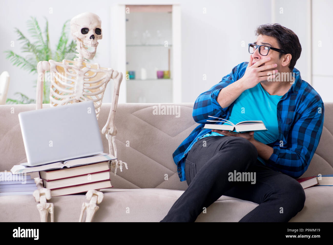 Student studying with skeleton preparing for exams Stock Photo