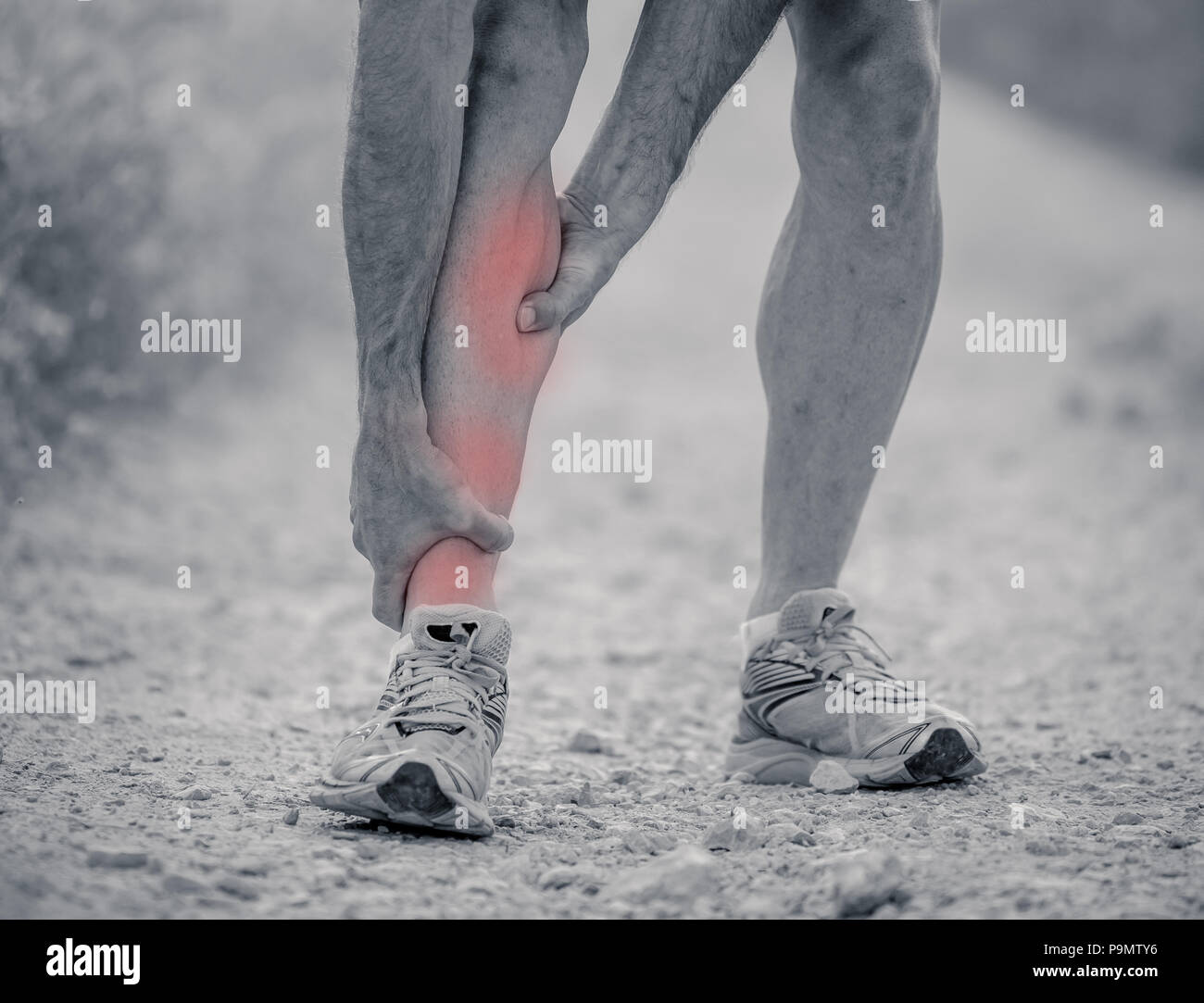 black and white close up of runner touching painful twisted or broken