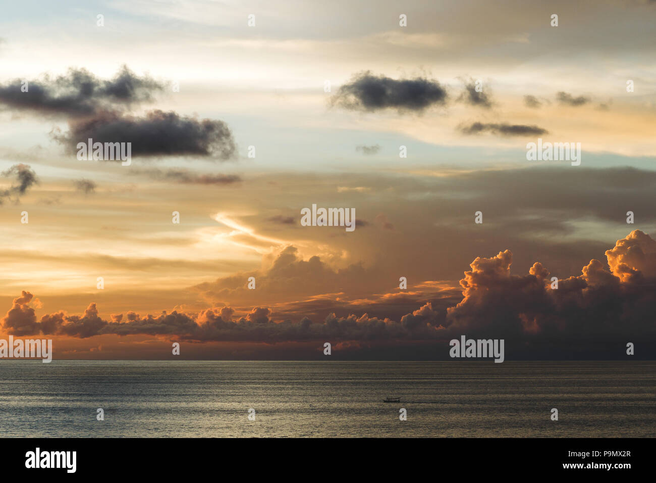 Amazing cloudy sunset sky above the sea with boat in Bali Stock Photo ...