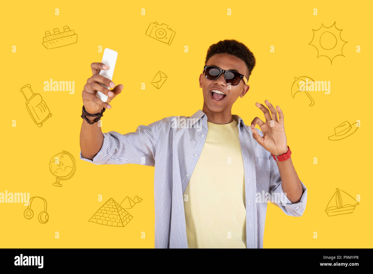 Optimistic boy winking his eye and smiling while taking a selfie Stock Photo