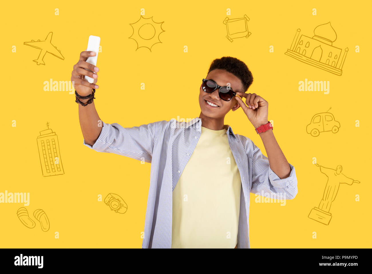 Relaxed student touching his sunglasses while taking a selfie Stock Photo
