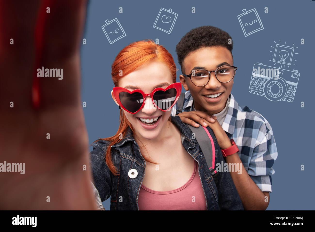 Happy girl holding a camera and taking selfie with her boyfriend Stock Photo