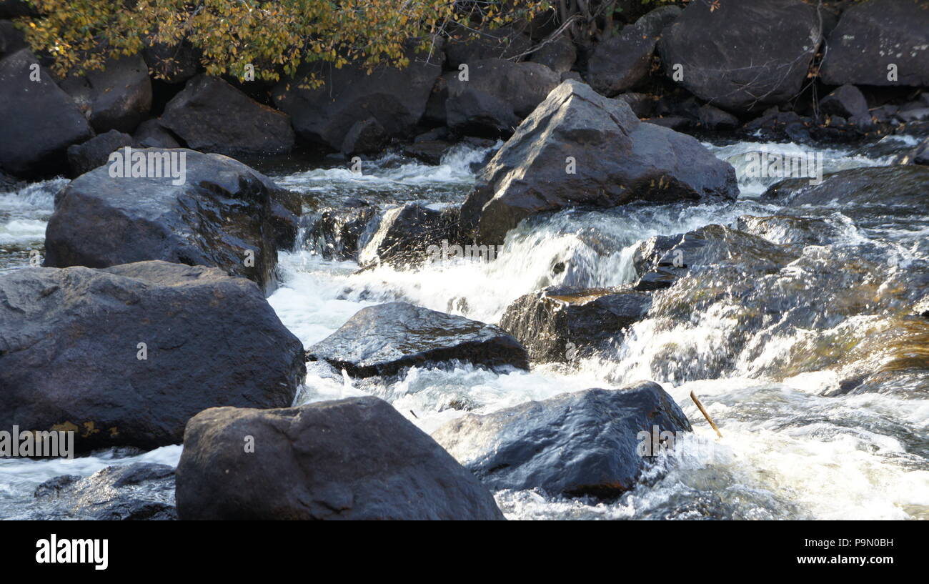 water crashing on the rocks in the middle of the river Stock Photo