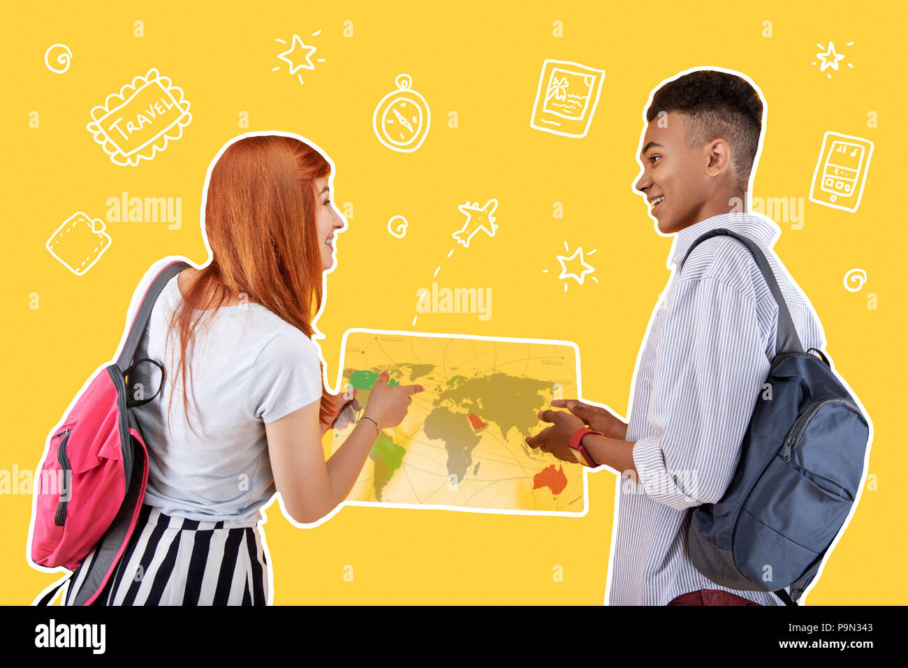 Excited friends standing with a map and smiling to each other Stock Photo