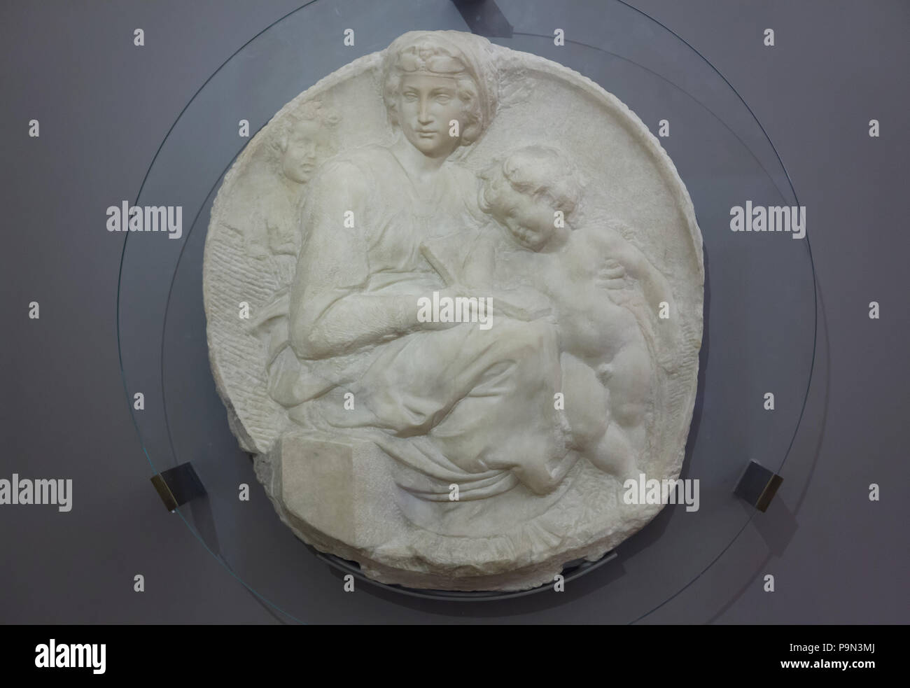 Marble relief of Madonna and Child with Young Saint John the Baptist, known as the Pitti Tondo by Italian Renaissance sculptor Michelangelo Buonarroti (ca. 1505) on display in the Bargello Museum (Museo Nazionale del Bargello) in Florence, Tuscany, Italy. Stock Photo