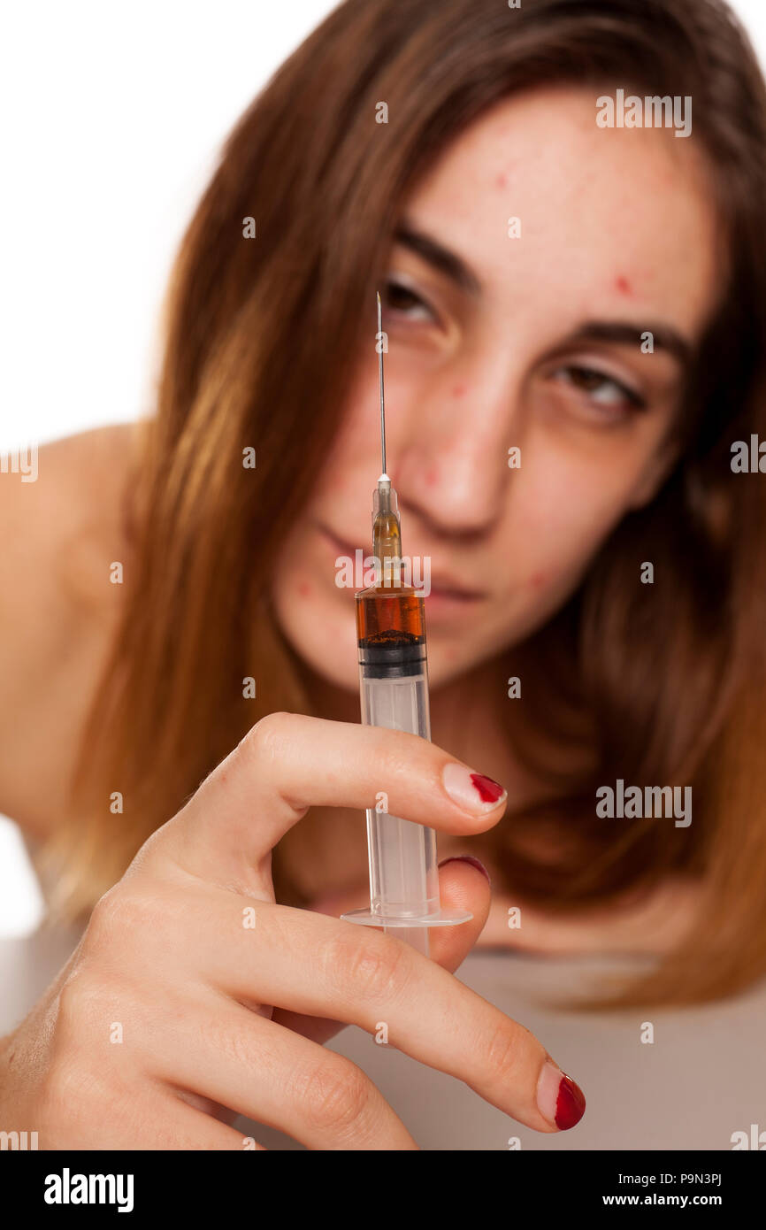 A girl with syringe and dark circles around her eyes. Drugs addiction concept Stock Photo