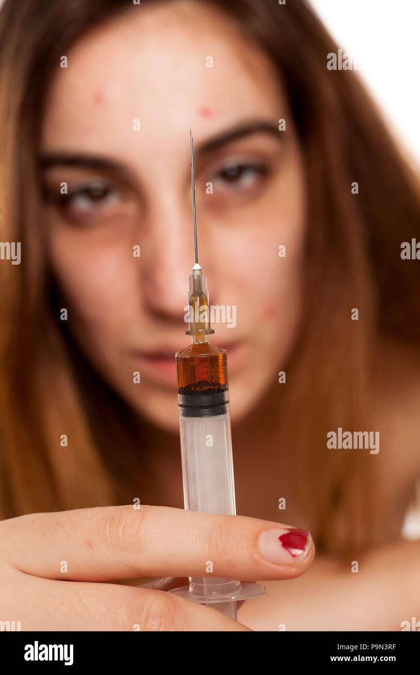 A girl with syringe and dark circles around her eyes. Drugs addiction concept Stock Photo