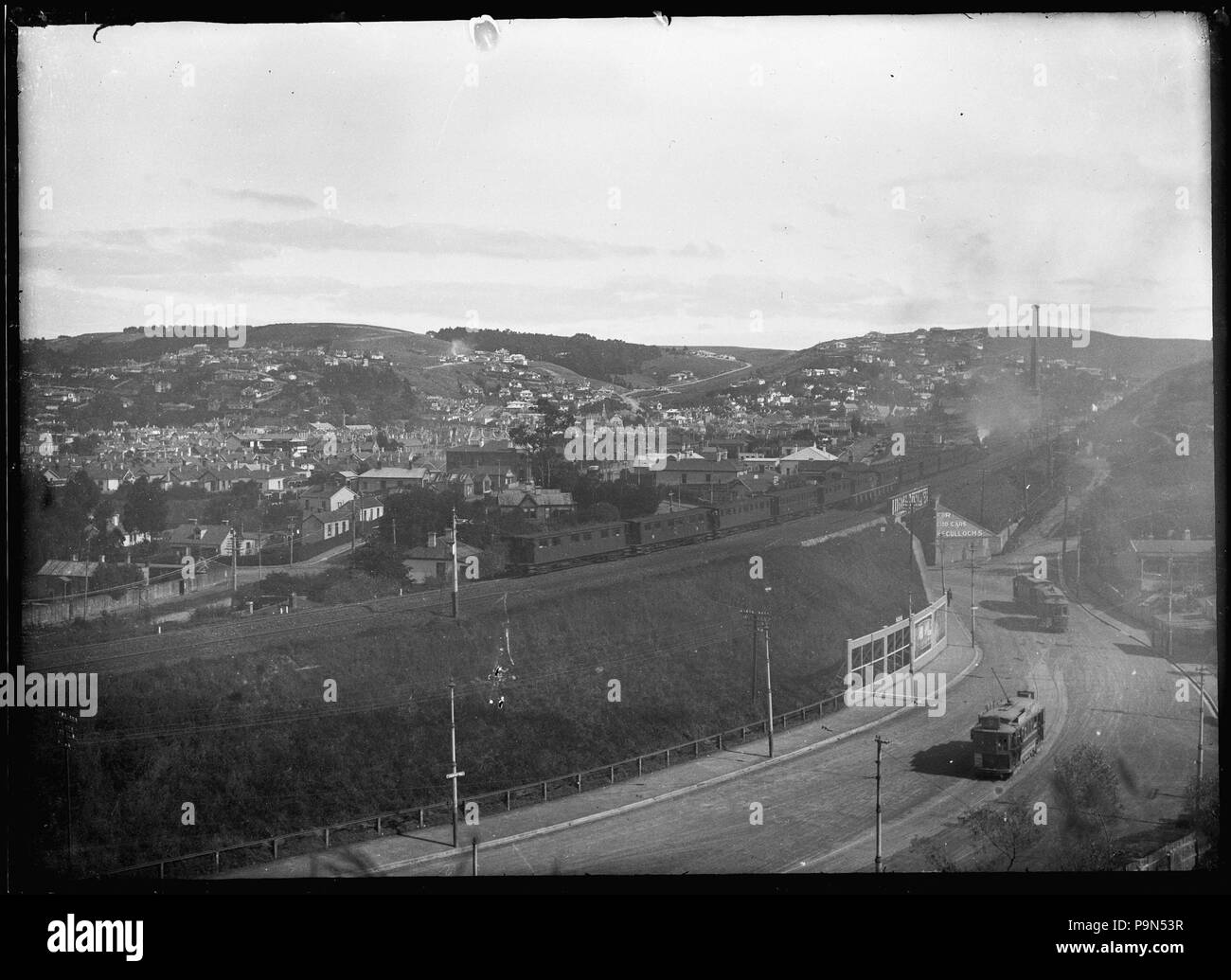 324 View of The Glen, South Dunedin, with a train crossing the railway overpass above South Road. ATLIB 274010 Stock Photo