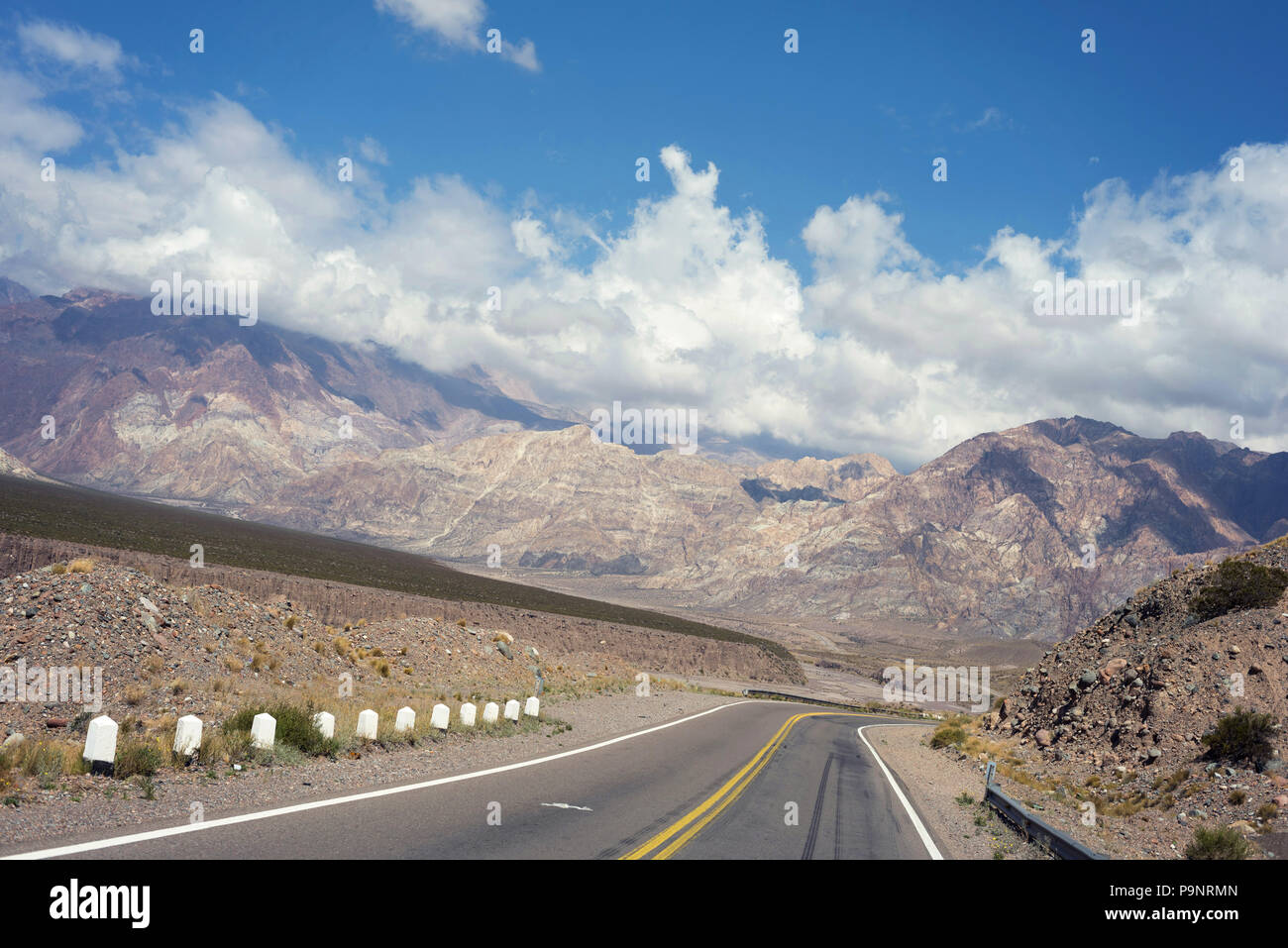 Mountain nature landscape with empty road and blue sky background. Adventure travel in Los Andes mountain Argentina, beautiful desert hill scenery of  Stock Photo