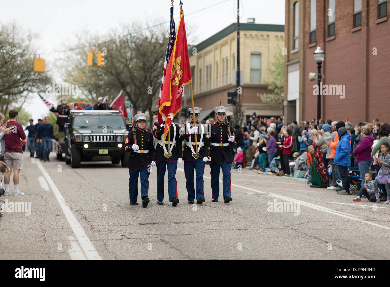 Holland, Michigan, USA - May 12, 2018 US Marines carrying the American Flag marching down the road at the Muziek Parade, during the Tulip Time Festiva Stock Photo