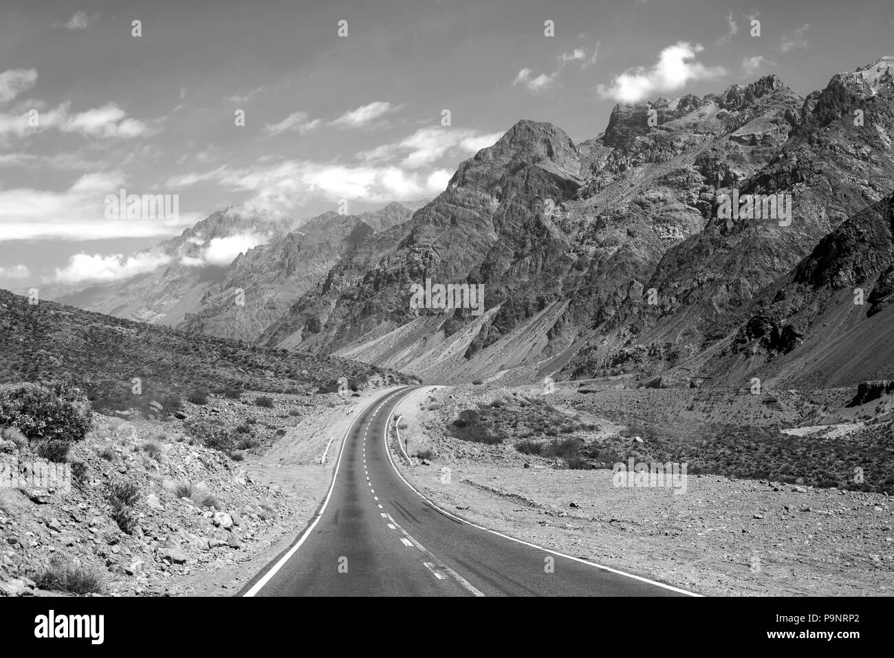 Mountain desert landscape with rocky hills and empty road of Argentina, south america in black and white. Stock Photo