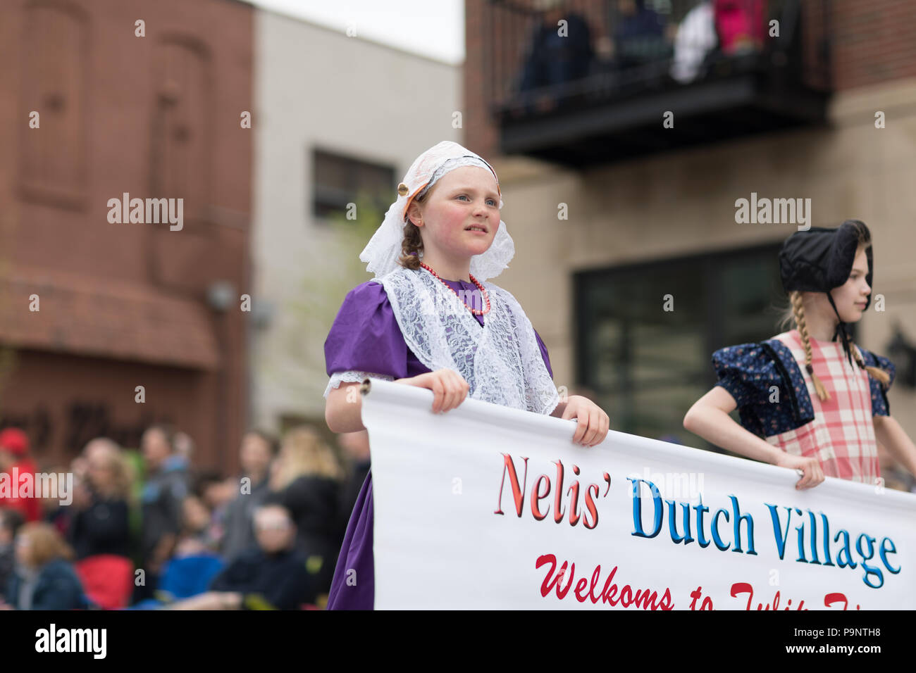 Holland, Michigan, USA - May 12, 2018 A girl wearing traditional dutch cloting at the Muziek Parade, during the Tulip Time Festival Stock Photo