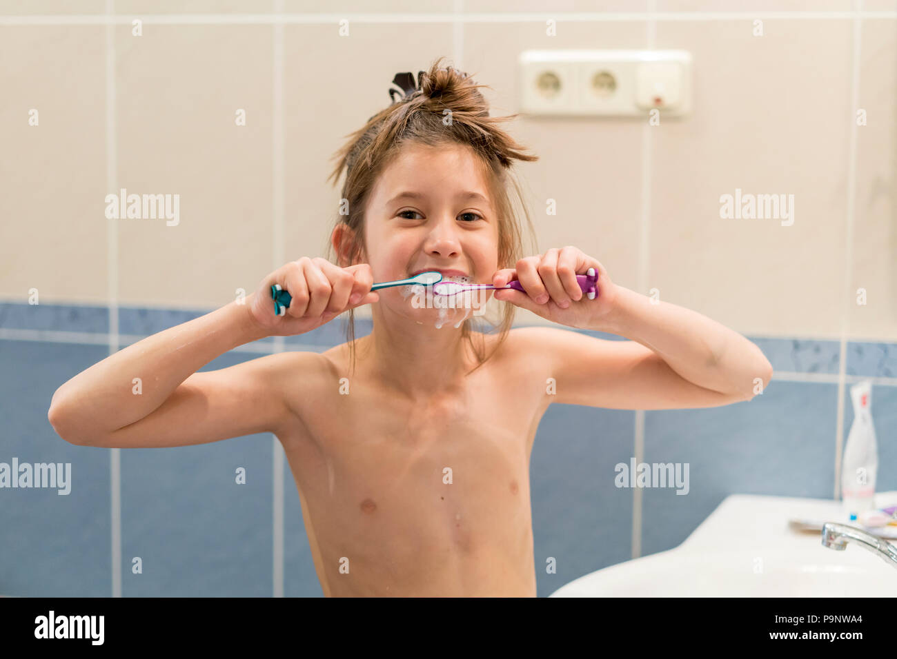 Little girl brushes teeth with two brushes. Stomatology. oral health